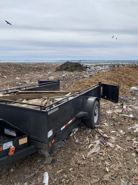 Dump trailer loaded with wood debris being unloaded at the landfill